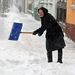 Havat lapátol egy nő Nagykanizsán, a kiskanizsai városrészben.