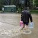 Egy ember ásványvizet visz az áradó vízben Miskolcon a Kilián városrészben, miután az esőzések következtében megáradt és kiöntött a Szinva patak.