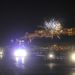 Tűzijátékot lőnek egy hajó fedélzetéről, miközben résztvevők vonulnak a Parlament előtti rakparton