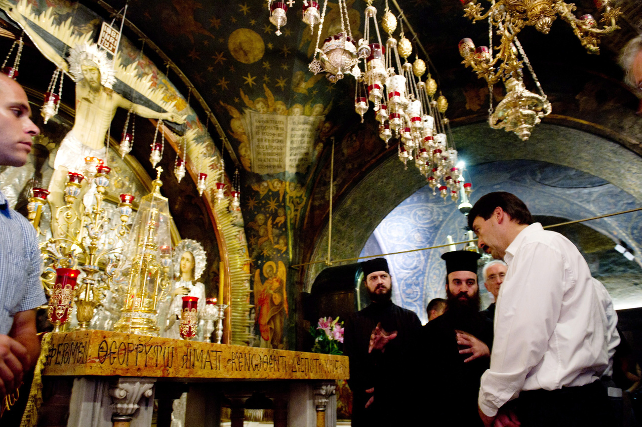 A köztársasági elnök gyertyát gyújt Jézus jászlának feltételezett helyénél a Születés Templomában.