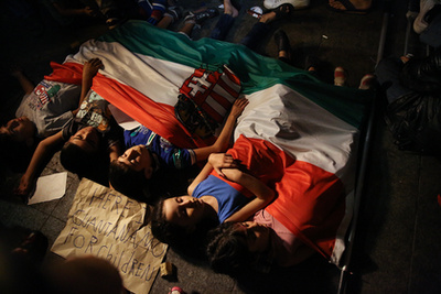 Gyerekek pihennek egy magyar zászlóval letakarva a Keletinél.