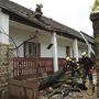 A viharos szélben letört fa által megrongált háztetőn dolgoznak tűzoltók Pomázon