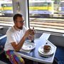 Egy utas hamburgert eszik az étkezőkocsiban a Budapest-Déli–Székesfehérvár között közlekedő különvonaton