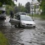 A felgyülemlett esővíztől elmozdult csatornafedél miatt a vízelvezetőben elakadt személygépkocsi a Maglódi úton 2023. június 9-én