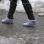 Egy gyalogos csizmára húzott zokniban az ónos esőtől jeges járdán Nagykanizsán a Huszti téren 2017. február 1-jén