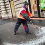 A Fővárosi Közterület-fenntartó Zrt. (FKF Zrt.) munkatársa csúszásgátló anyagot szór a járdára Budapest belvárosában 2017. január 31-én
