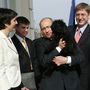 Vlagyimir Putyin orosz elnök (k) megöleli Gyurcsány Ferenc magyar miniszterelnök (j) és felesége, Dobrev Klára (b) puli kutyáját a miniszterelnöki rezidencia erkélyén 2006. március 1-jén