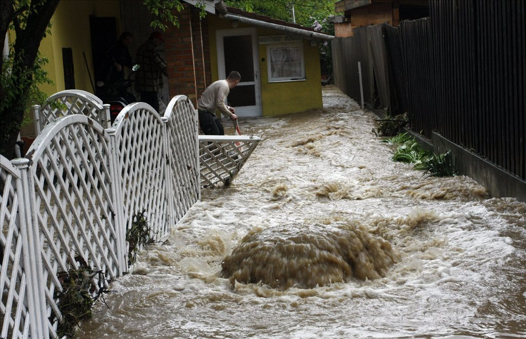 Víz tör fel a csatornából egy ház udvarán Miskolcon a Hóvirág utcában, miután a heves esőzéstől megáradt és kiöntött a Szinva patak. 
