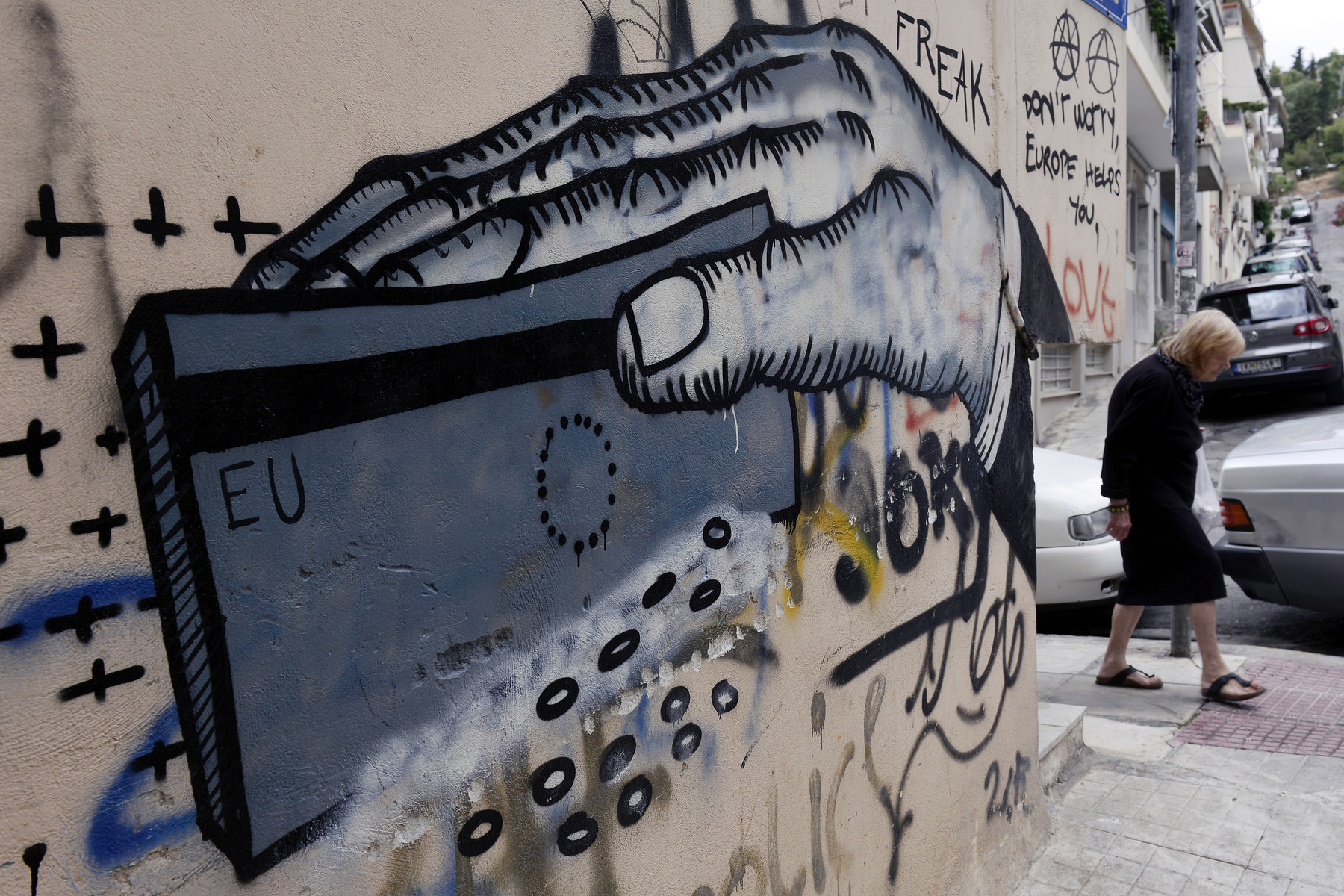 A görög utcai művészeket is nyilván foglalkoztatta, hogy az országuk egyre kilátástalanabbul sodródik a csőd felé egy ideje. A bizonytalan jövőtől való félelem, a népszavazás, a Merkeléktől való függés vagy az eurózónából való kilépés közeli lehetősége kerül elő ezeken graffitiken. A képek június-júliusban készültek. 