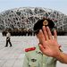 Egy kínai katonai rendész megpróbálja megakadályozni, hogy fényképek készüljenek egy katonai parádé főpróbájáról a Madárfészeknek nevezett pekingi olimpiai stadion közelében