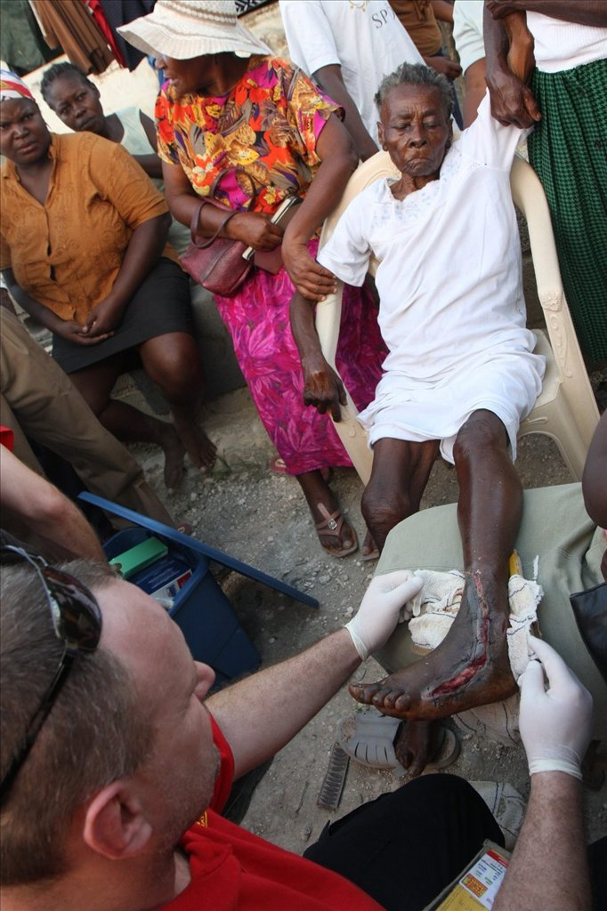 Pavelcze László, a Magyar Baptista Szeretetszolgálat Katasztrófavédelmi Szolgálatának vezetője ellát egy sérült gyermeket Port-au-Prince-ben 2010. január 16-án, miután négy nappal korábban a Richter-skála szerinti 7-es erősségű földrengés rázta meg Haitit