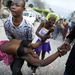 Jeff Cherisma 15 éves húga holttestével. Fabienne-t egy fosztogatókat üldöző rendőr lőtte le Port-au-Prince-ben.