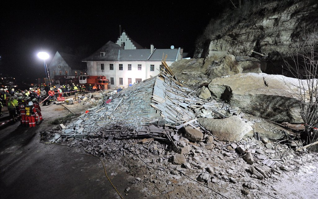 Mentőalakulatok tagjai dolgoznak egy lakóház romjai között azt követően, hogy az épületre egy hatalmas szikladarab zuhant a felső-bajorországi Traunban 2010. január 25-én. Az otthon tartózkodó családapa, valamint 18 éves lánya életét vesztette, a férfi feleségét és 16 éves fiát élve sikerült kimenteni a romok közül.