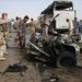 Felrobbantott autó és kiégett busz maradványait állják körül katonák, rendőrök és civilek a Bagdadtól 160 kilométernyire délre fekvő Nedzsefben 2010. március 6-án, a parlamenti választások előtt egy nappal. Az Iránnal szoros kapcsolatot tartó, síita szent városban autóbombás merényletet követtek el. A gépkocsiba rejtett pokolgép robbanása következtében legkevesebb három személy - két iráni és egy iraki zarándok - életét vesztette, 54 ember - köztük három iraki rendőr - pedig megsebesült.