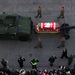 Az ágyútalpon vontatott koporsót, amelyben Lech Kaczynski lengyel elnök földi maradványai vannak, a lengyel katonai díszőrség tagjai kísérik a Varsóban tartott állami gyászszertartáson.