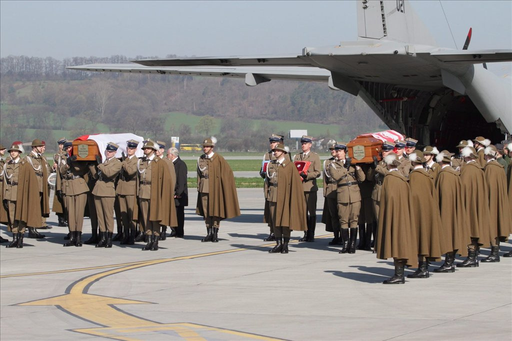 Lech Kaczynski lengyel elnök és hitvese nemzeti lobogóval letakart koporsóját a katonai díszőrség tagjai repülőgépre rakják a varsói katonai repülőtéren.
 	 