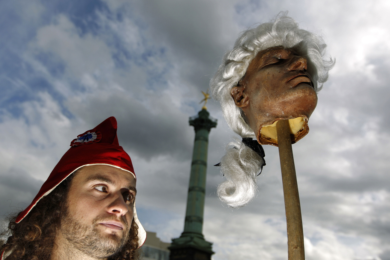Francia szabadságharcosnak öltözött férfi phrügiai kalapban, dárdára tűzött műfejjel tüntet