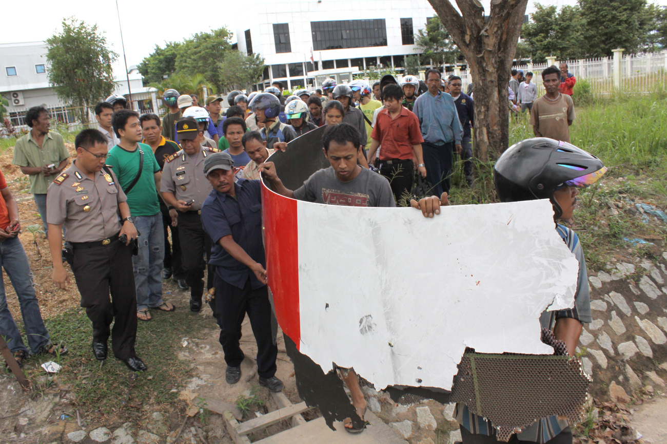 Indonéziaiak egy csoportja a gépről leszakadt borítással