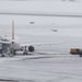 Hóeke dolgozik egy jégtelenítés nélkül veszteglő repülőgép közelében Genf nemzetközi repülőterén 