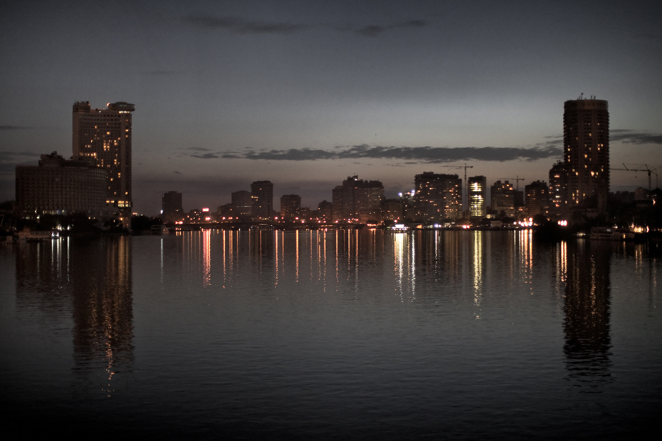 Nílus parti épületek árnyai láthatóak a naplemente után Kairóban