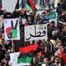 Az emberek monarchia korabeli líbiai zászlókat lengetnek, amint a szövetséges erők által a Kadhafi líbiai vezető csapatai ellen végrehajtott légicsapásokat támogatva tüntetnek a felkelők székhelyén, Bengáziban. 