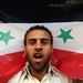 A szíriai kormányt támogató tüntető szír zászlóval a nyakában tüntet a beiruti szír nagykövetség előtt