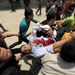 Mohammed Otman sebesült palesztin fotóriportert viszik tüntetők Gázai övezet és Izrael közötti erezi ellenőrző pontnál,