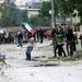 Palesztin fiatalok kővel dobálnak izraeli katonákat a ciszjordániai Hebronban