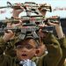 Palesztin kisfiúk játékfegyvereket emelnek fel egy ünnepségen, amellyel a palesztinok megemlékeznek Izrael megalapításának, az arabok szempontjából a nakbának, a katasztrófának a 63. évfordulójáról 