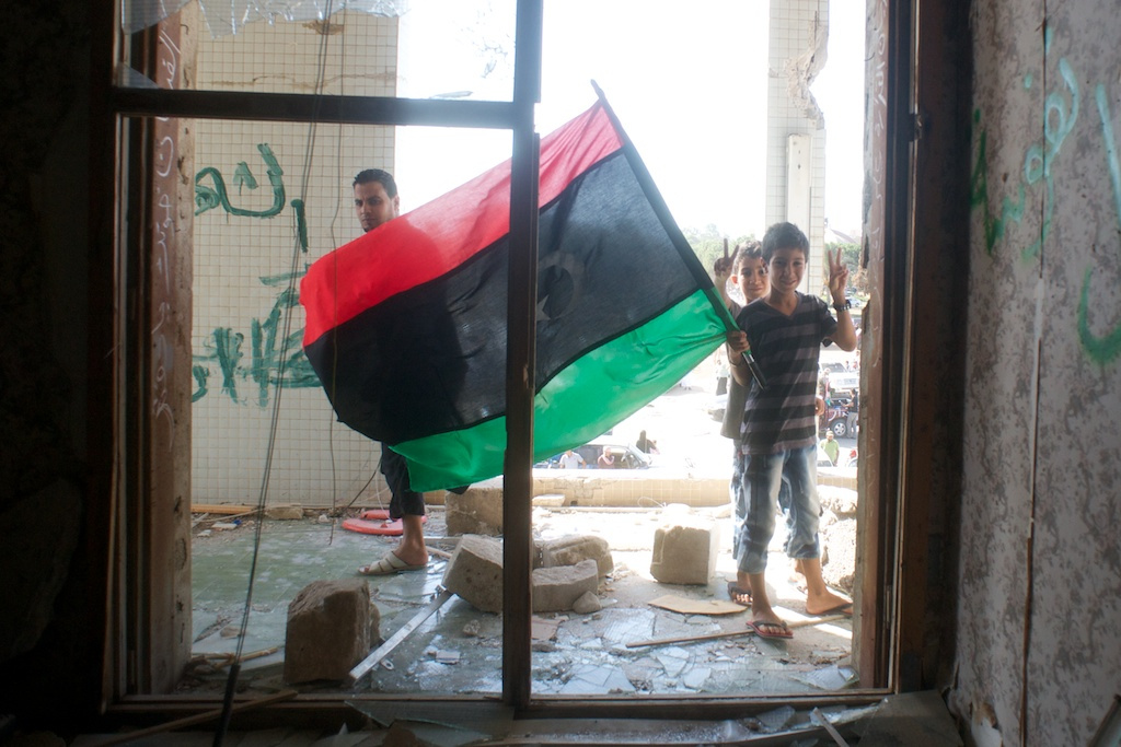 Boldog líbiaiak mennek be Kadhafi egyik kerti házába.