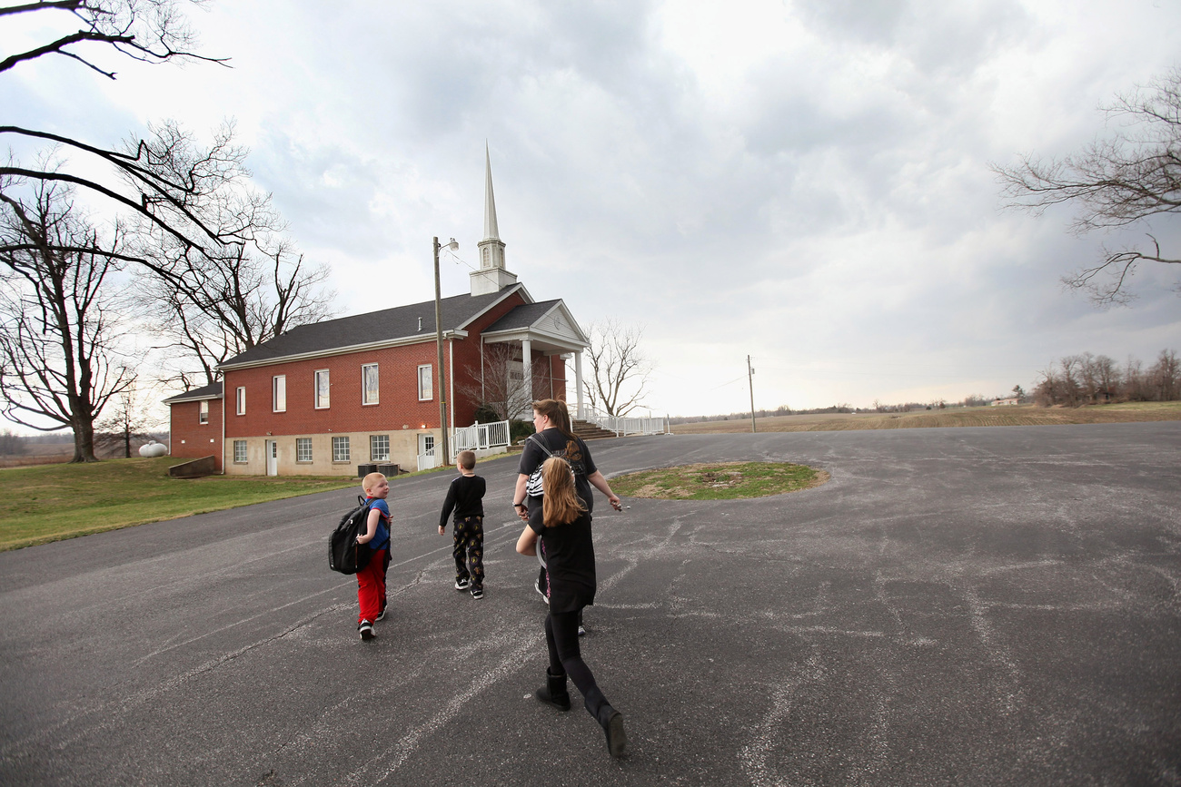 Egy asszony gyermekeivel a baptista templom alagsorába menekül, miután kiadták a tornádóriasztást (Fredonia, Kentucky)