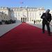 A szigorú protokollszabályoknak megfelelően az Elysée-palota lépcsőjén Sarkozy fogadta a gépkocsin érkező Hollande-ot, aki kamerák kereszttüzében, vörös szőnyegen vonult át az elnöki hivatal díszudvarán. 