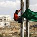 Palesztin fiú Hamasz zászlóval a kezében a határ közelében
