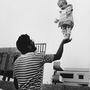 Gyermekét tartja magasba egy férfi, 1990.