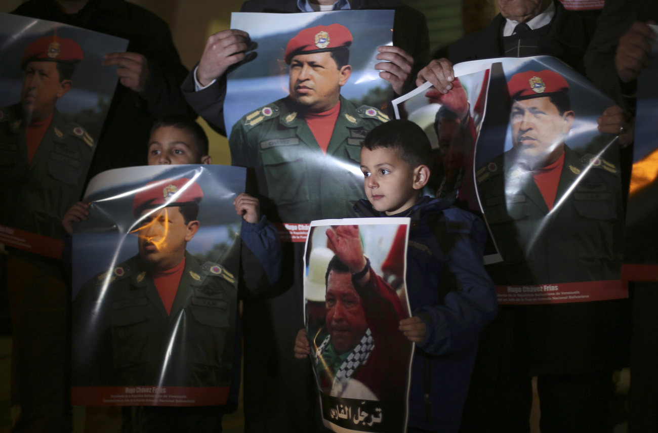 Palesztinok az elhunyt venezuelai elnök képeivel Ramallahban, 2013. március 6-án.