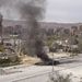 A kormányerőkhöz tartozó, kilőtt tank füstölög a Damaszkuszba vezető úton. A háború lassan a harmadik évébe lép, azonban kevés remény van a gyors lezárásra. 