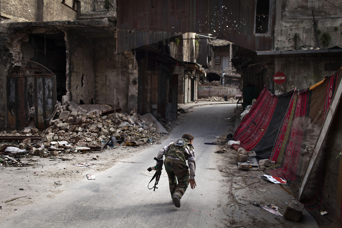 A kormányerőkhöz tartozó, kilőtt tank füstölög a Damaszkuszba vezető úton. A háború lassan a harmadik évébe lép, azonban kevés remény van a gyors lezárásra. 