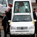XVI. Benedek a pápamobilban homlokon puszil egy csecsemőt 2008-ban, sydneyi útján. XVI. Benedek először járt Ausztráliában.