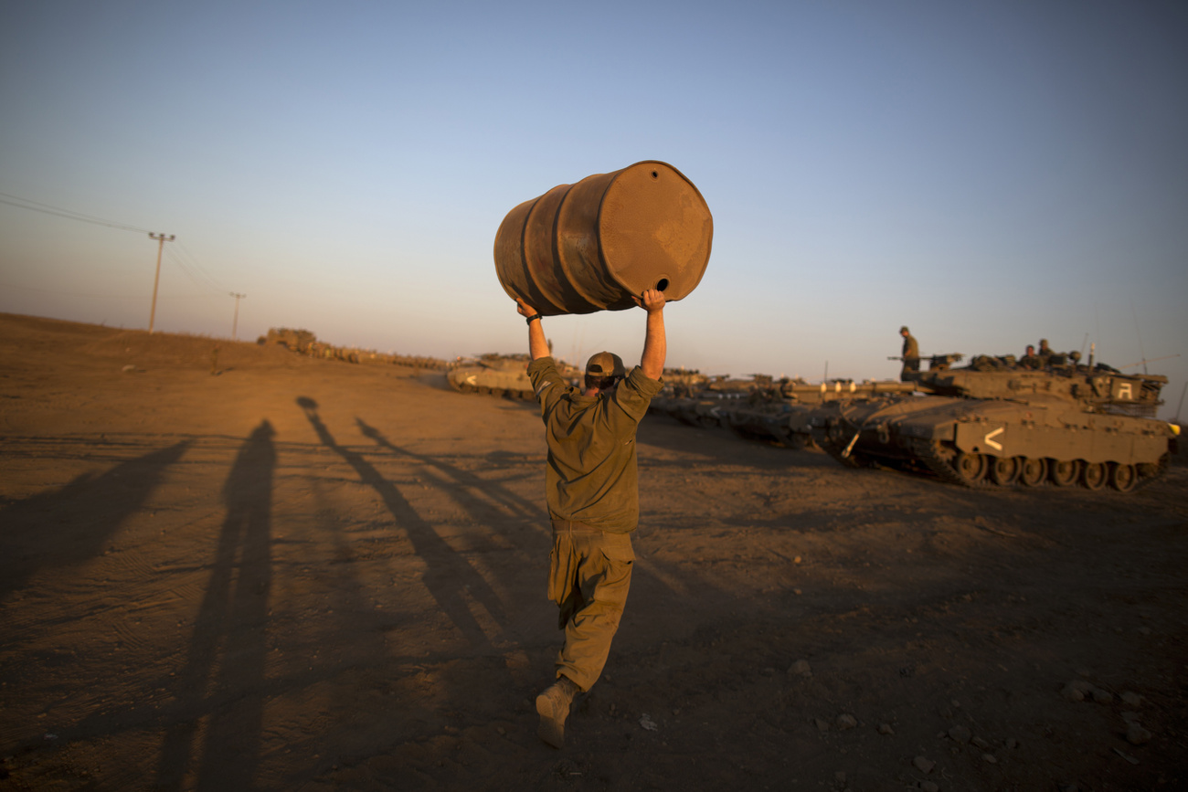 Egy izraeli katona ellenőrzi Merkava típusú harckocsijának lövegét.