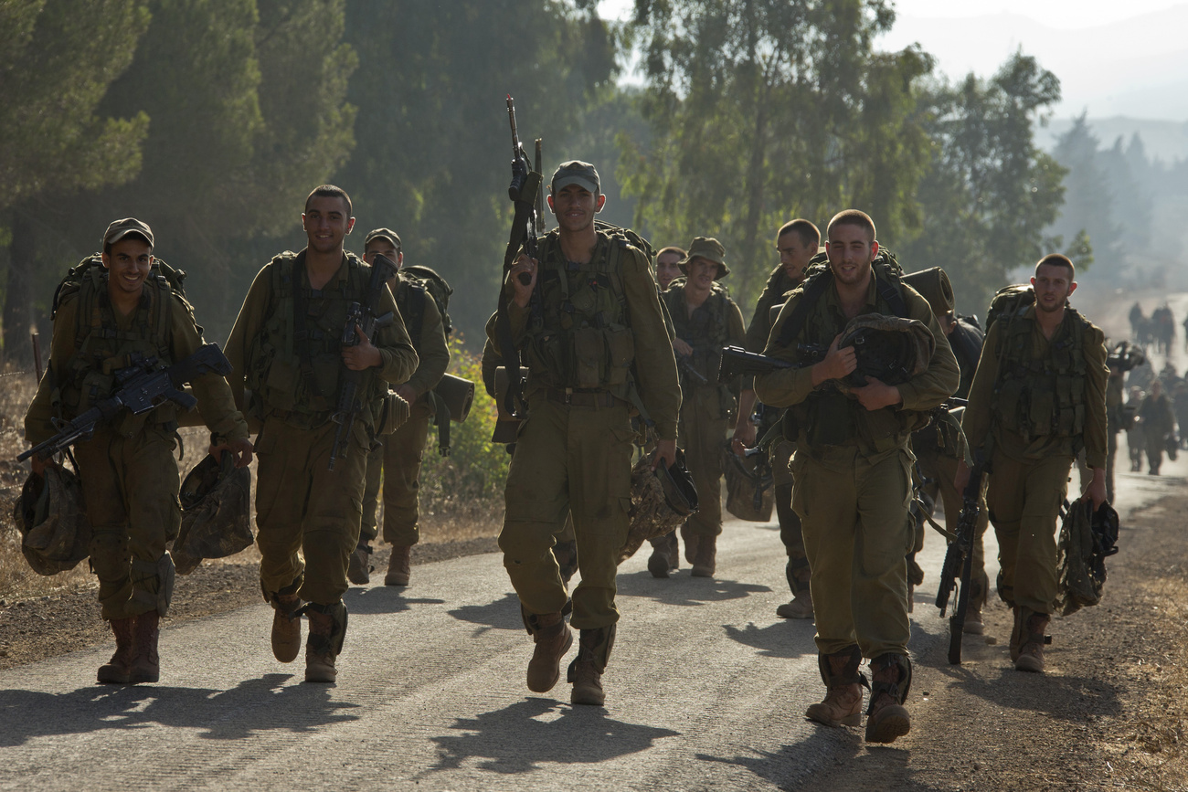 Egy izraeli katona ellenőrzi Merkava típusú harckocsijának lövegét.
