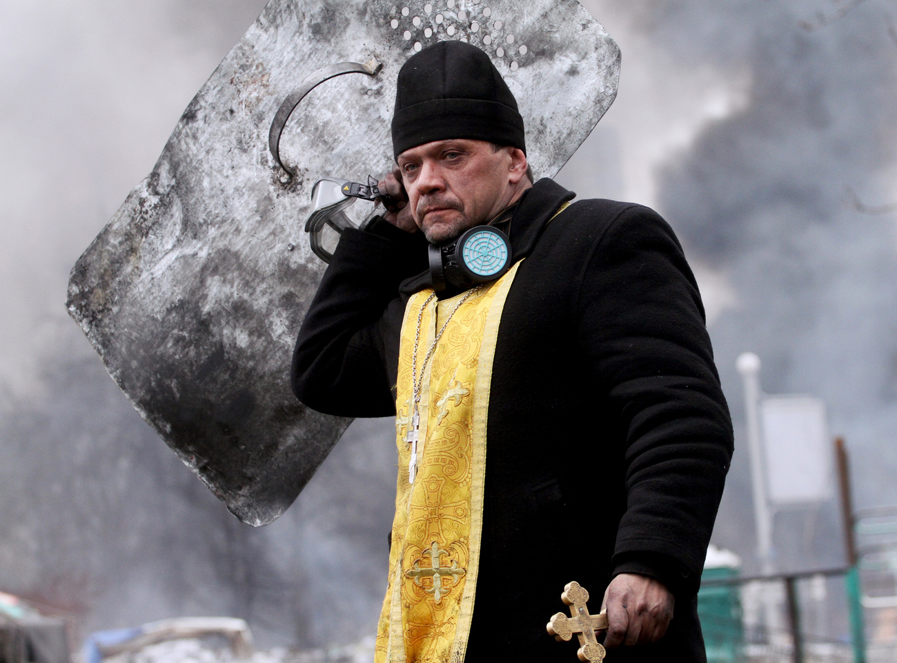 Rohamsisakos pap a Szakszervezetek Háza kiégett romjai között