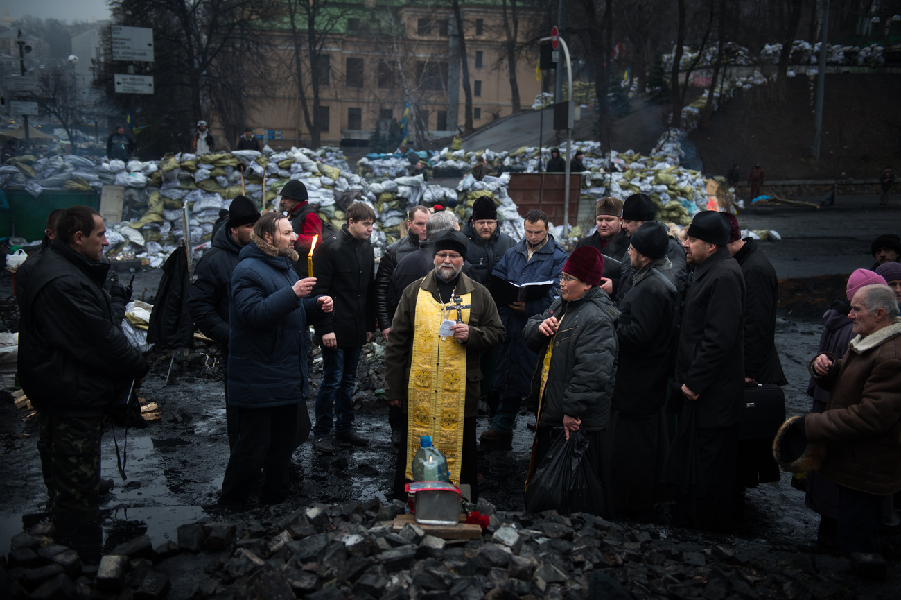 Rohamsisakos pap a Szakszervezetek Háza kiégett romjai között