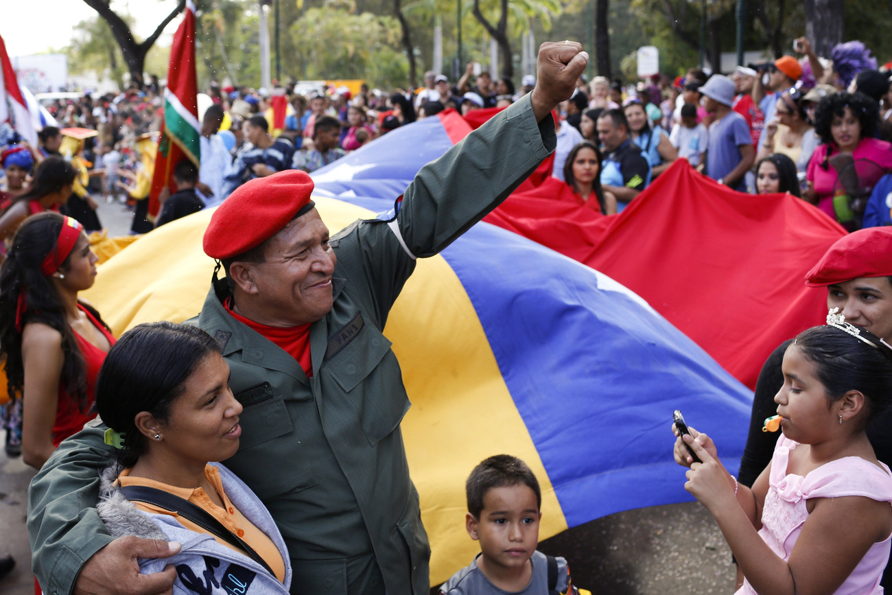 Chávez egyik híve zászlót tűz egy a volt elnök képével díszített falra, a 
