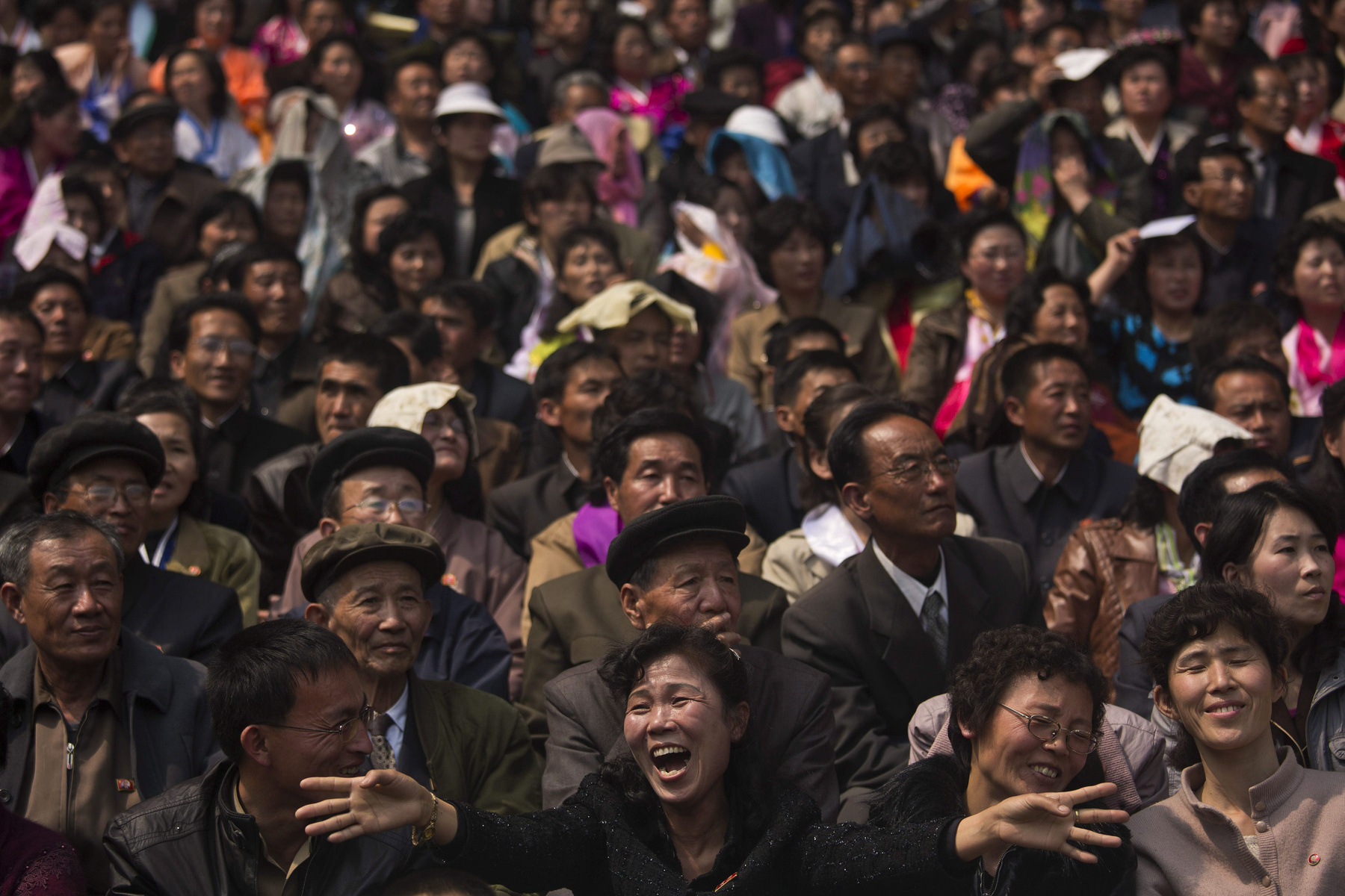 Észak-koreai népviseletbe öltözött nők a futópálya mellet.