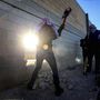 Palesztin aktivisták lyukat ütnek a ciszjordániai falon a berlini fal lebontásának évfordulóján. 