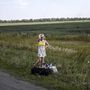Egy ukrán lány menekül a harcok elől a megmaradt holmijaival Grabovóból.