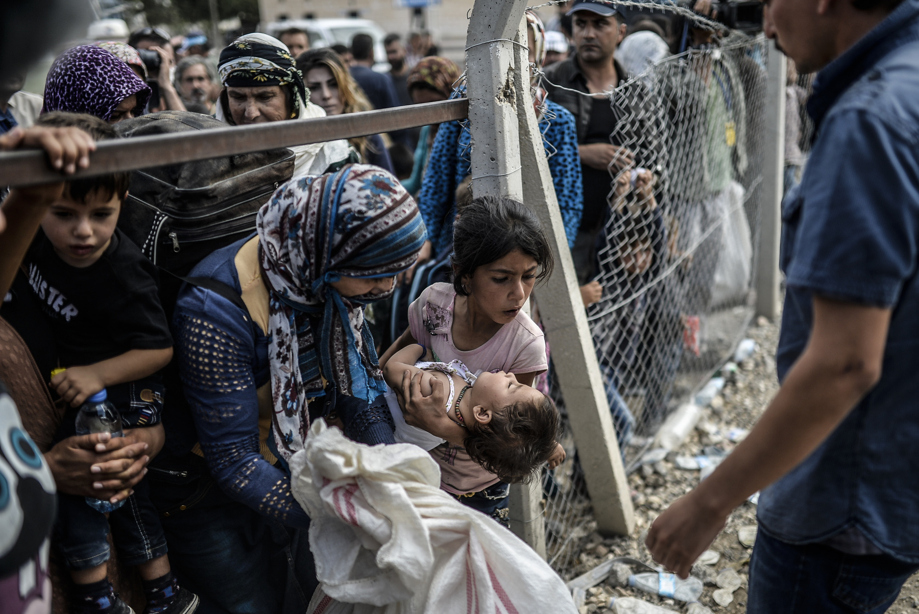 Bulent Kilic (középen) kurd menekülteknek mutatja a fotóit egy szíriai menekülttáborban.