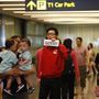 Egy repülőtéri alkalmazott várakozik az AirAsia QZ8501-es járat utasaira a Changi repülőtéren, Szingapúrban.
