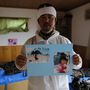 Norio Kimura a vízből megmentett családi fotókat rendezgeti otthonában