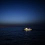 Menekülteket szállító csempészhajó navigál az éjszakában a Földközi tengeren.